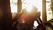 Young woman laying on motorcycle