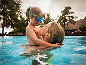 Mother and son hugging in swimming pool