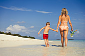 Mother and son walking on tropical beach