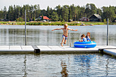 Boy jumping from dock into lake