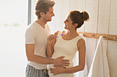 Pregnant couple brushing teeth