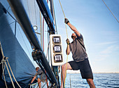 Man adjusting sailing equipment