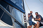 Men sailing pulling rigging equipment