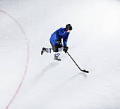 Hockey player in blue uniform skating