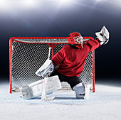 Hockey goalie in red uniform at goal net