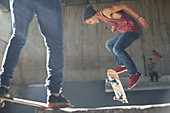 Boy flipping skateboard at skate park