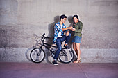 Teenage couple with BMX bicycle texting