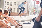 Friends watching boy jumping skateboard