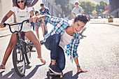 Boy skateboarding with friends