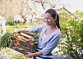 Woman holding fresh harvested vegetables