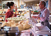 Deli worker offering cheese sample