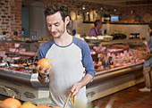 Man examining grapefruit in market