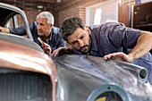 Mechanic examining classic car panel
