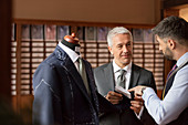 Tailor explaining suit to businessman