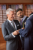 Tailor and businessman examining suit