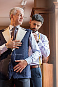 Tailor fitting businessman for suit