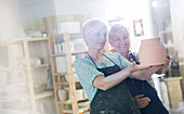 Women examining pottery in studio