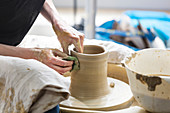 Woman using pottery wheel in studio