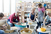 Mature students using pottery wheels