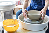 Senior man using pottery wheel in studio