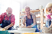 Senior couple using pottery wheels