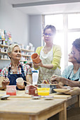 Mature students painting pottery
