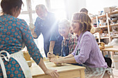 Smiling mature students in pottery studio