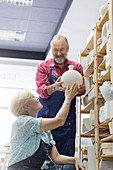 Smiling couple placing vase on shelf