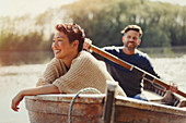 Smiling couple canoeing on sunny lake