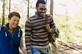 Couple holding hands hiking in woods