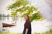 Portrait smiling woman at sunny lakeside