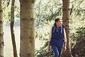 Smiling woman hiking in woods