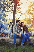 Couple posing for selfie near campfire