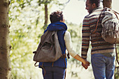 Couple with backpacks hiking in woods