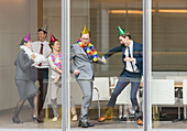 Business people in party hats dancing