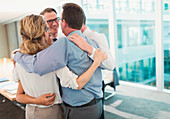 Business people hugging in conference room