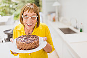 Mature woman holding chocolate cake