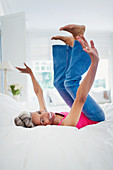 Portrait playful mature woman falling onto bed