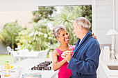 Smiling mature couple dancing in kitchen