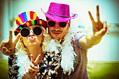 Couple in costume gesturing peace sign