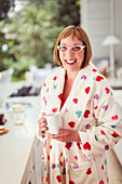 Mature woman drinking coffee in bathrobe