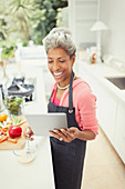 Mature woman with digital tablet cooking