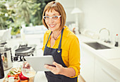 Mature woman with digital tablet cooking