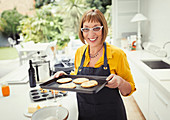 Mature woman baking cookies in kitchen