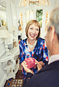 Smiling mature woman receiving gift from husband