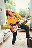 Mature woman playing electric guitar