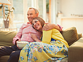 Couple watching TV and eating popcorn on sofa