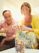 Mature couple depositing coins in savings jar