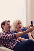 Playful couple making faces taking selfie