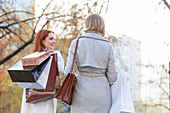 Women carrying shopping bags in city park